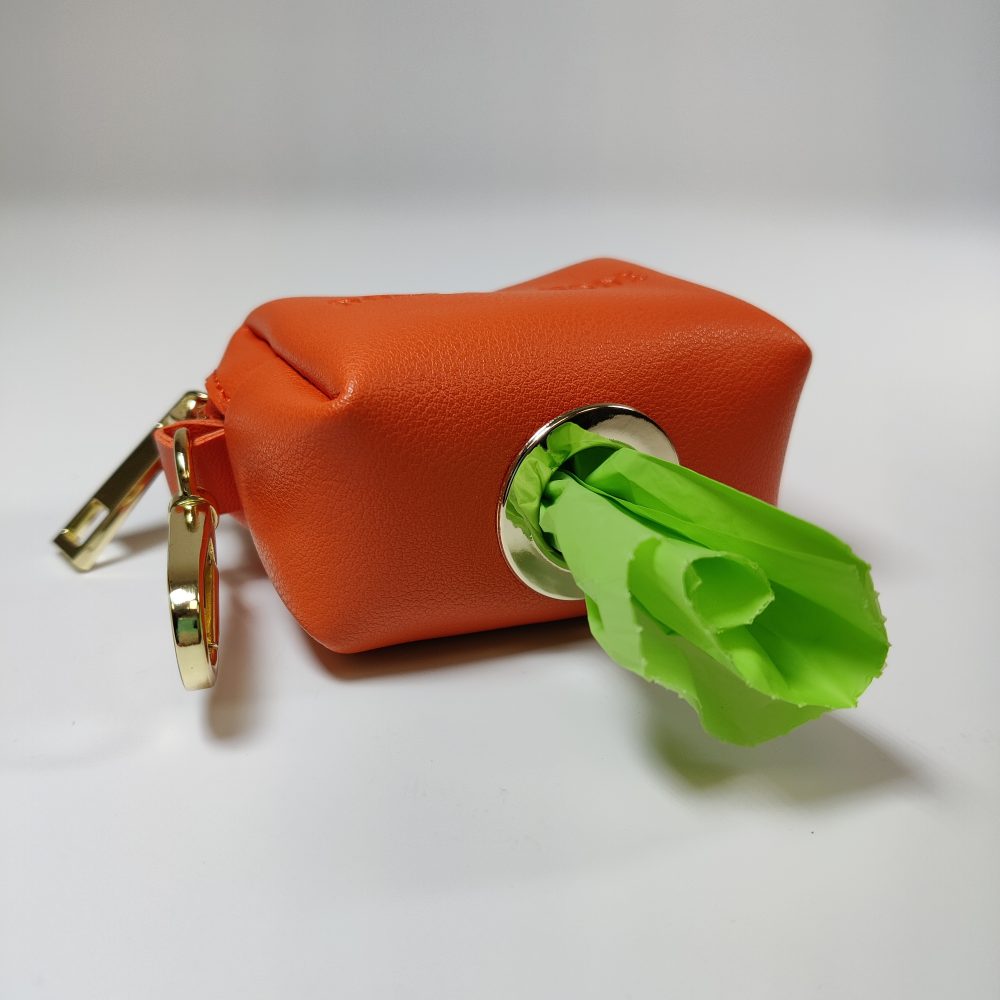 Dog A La Mode Le Classique vegan orange dog poop bag holder with the hole at the bottom of the stylish poop bag holder allowing biodegradable dog poop bags to come out of the hole