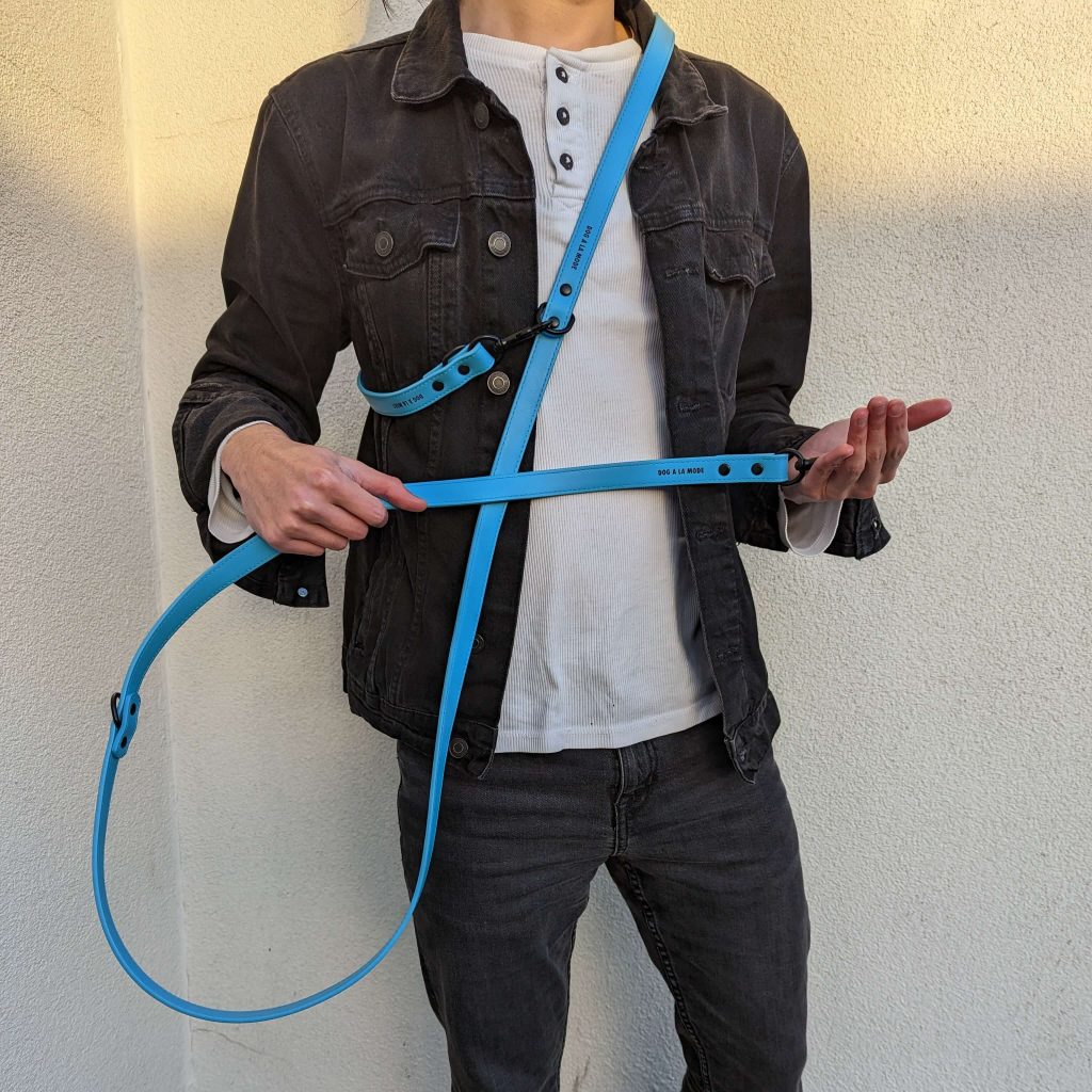 Man wearing and holding the Dog A La Mode hands free and double ended branded blue vegan dog lead