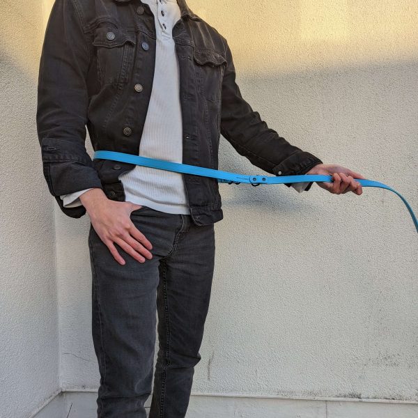 Man with a jean jacket and jeans wearing and holding the new Dog A La Mode double ended and hands free blue vegan dog lead across the waist outdoors