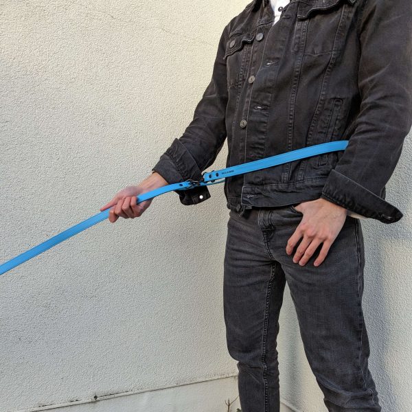 Man wearing and holding the new Dog A La Mode double ended and hands free blue vegan dog lead across the waist outdoors